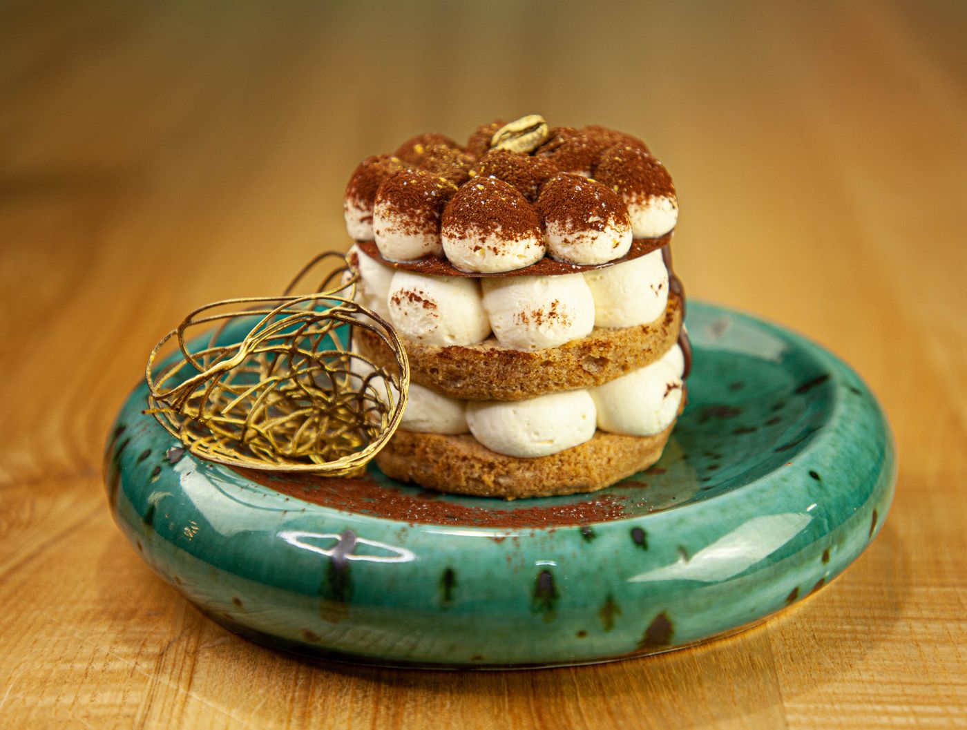 Tiramisu sur une assiette émaillée verte (photo d’illustration)
