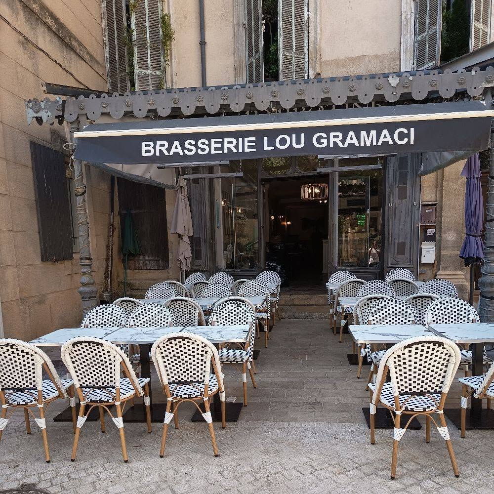La terrasse de la brasserie Lou Gramaci et ses chaises de bistrot tressées, place de l’Hôtel de ville à Manosque