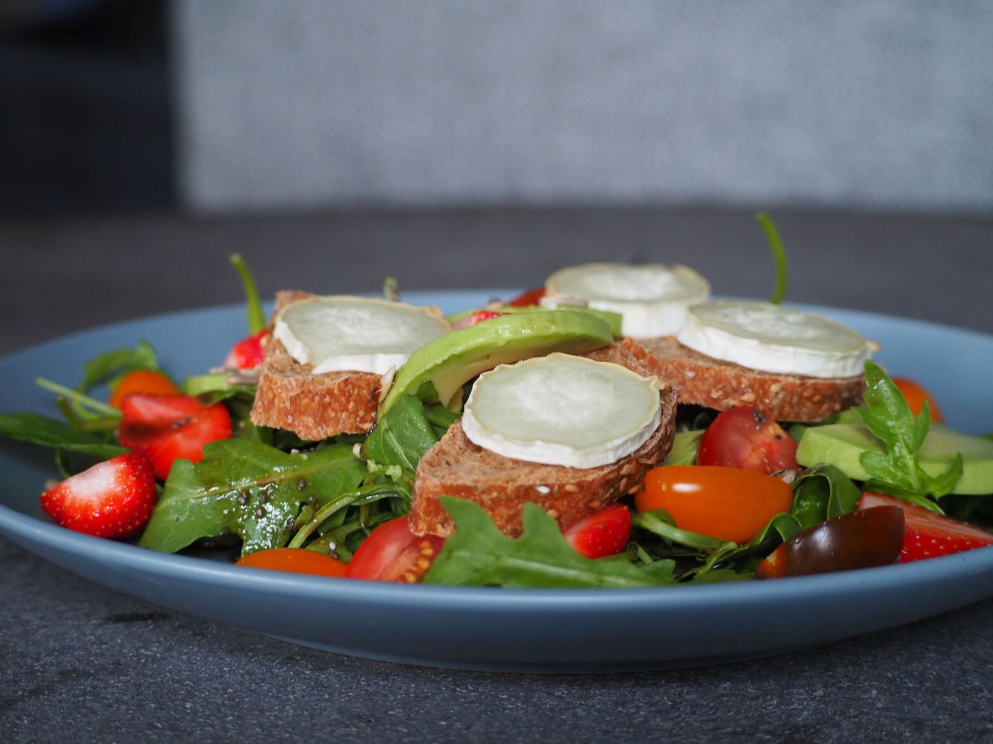 Grande salade au fromage de chèvre sur une assiette bleue (photo d’illustration)